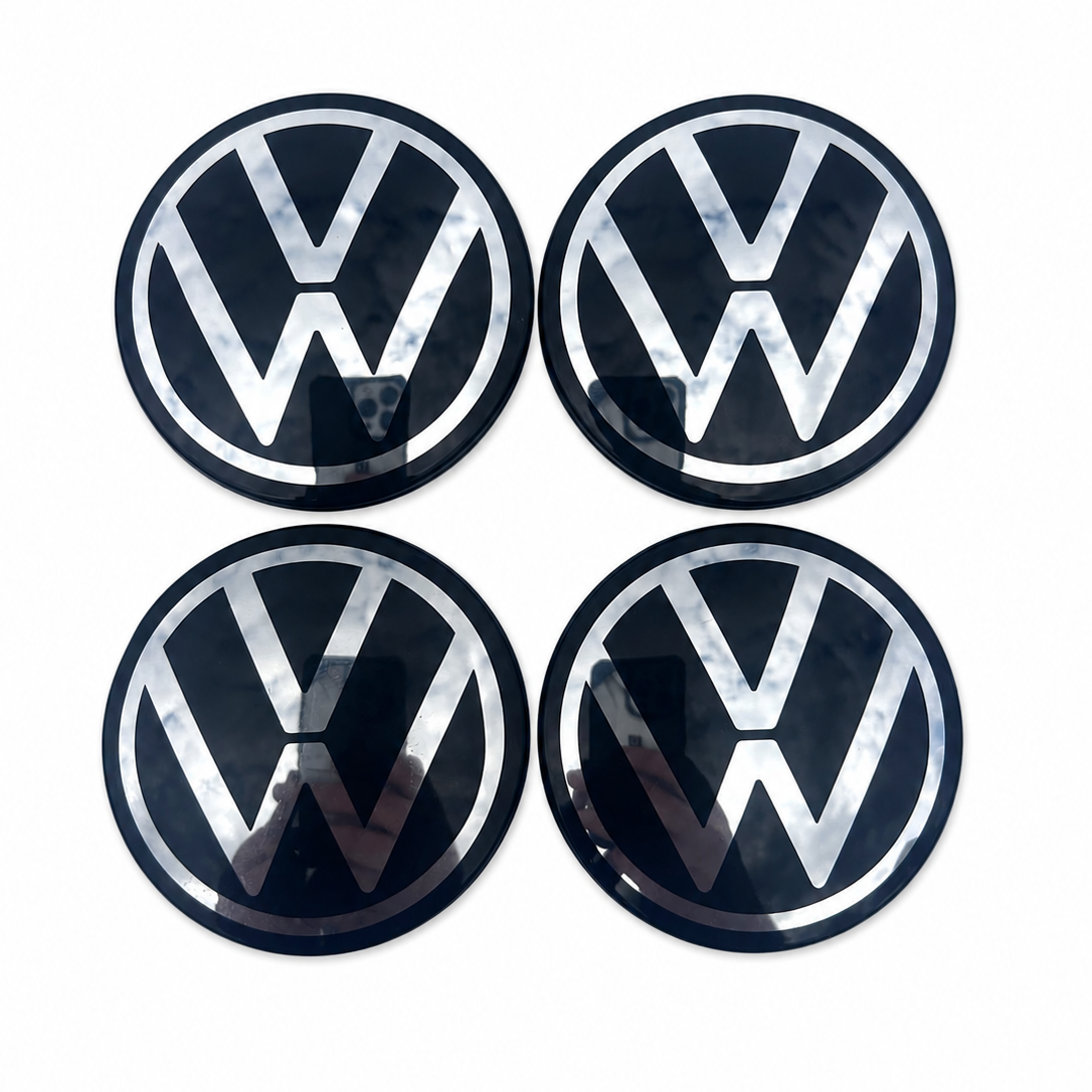 Four Volkswagen logo emblems on a white background